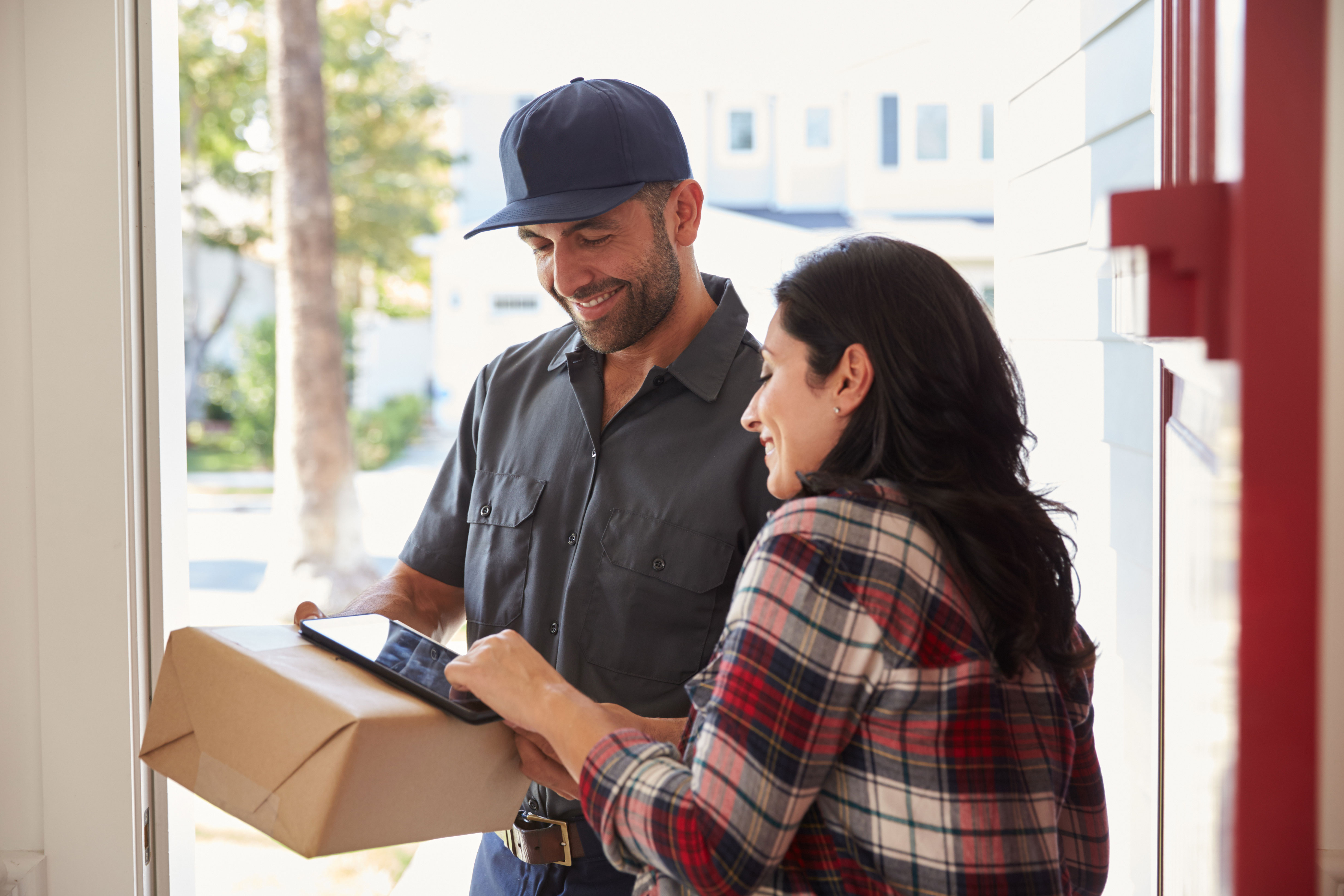 Delvery person handing a package to a happy customer